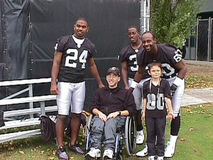 Charles Woodson (24), Phillip Buchanon (31) and Jerry Rice (80) pose for a photo with Kevin Matyko and Raymond Bautista after this morning's practice. Taken September 28th, 2002